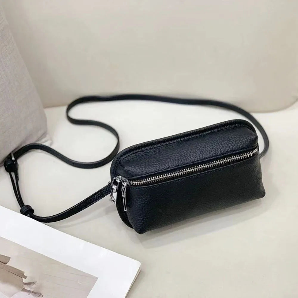 Mini crossbody bag in top grain leather with polyester lining, retractable handle, welt pocket, and solid colour patchwork design.