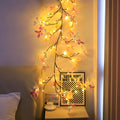 Tall flexible LED rattan tree lamp with colour-changing butterfly decorations lit up.
