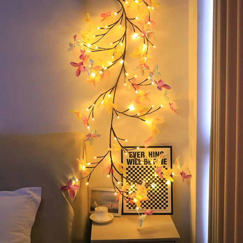 Tall flexible LED rattan tree lamp with colour-changing butterfly decorations lit up.
