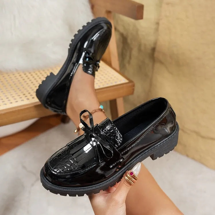 Brown women's flat loafers with a decorative bow on the front.