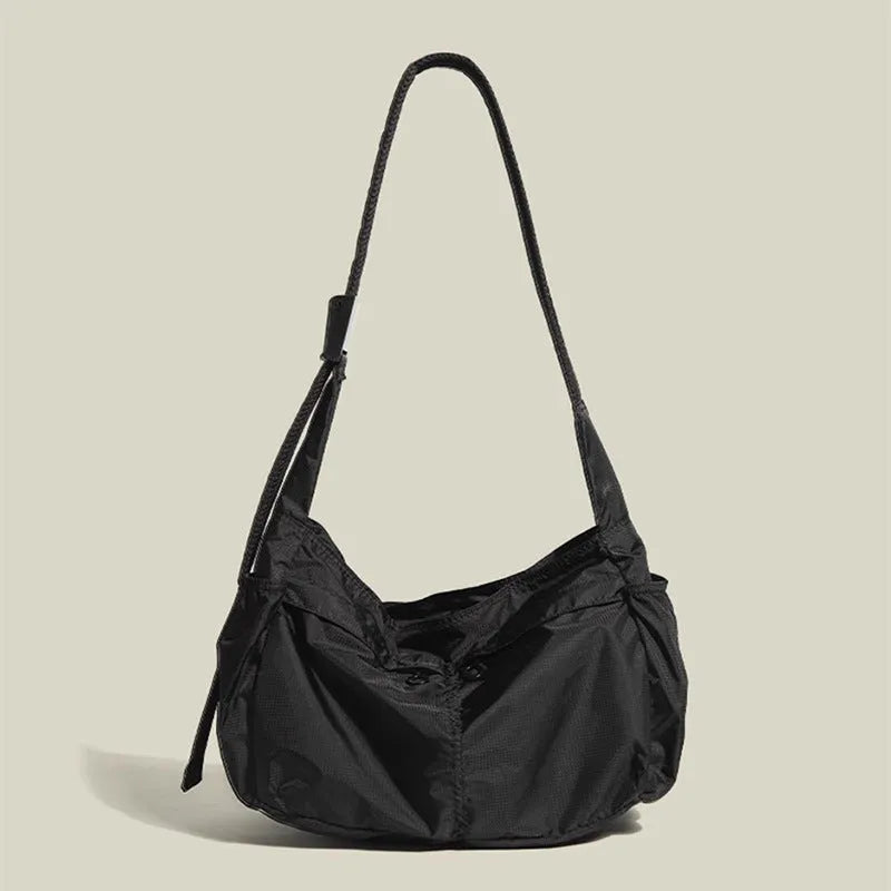 Nylon waterproof messenger bag in black with single shoulder strap and horizontal square design
