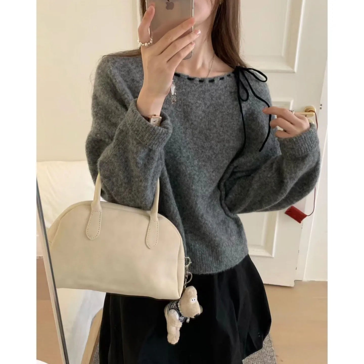 Grey loose-fitting women's long-sleeve knitwear pullover on a hanger.