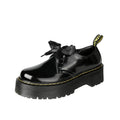 Black women's thick-soled lace-up shoes with decorative white ribbon cross straps.