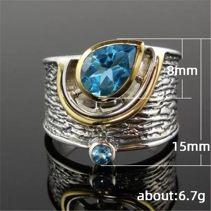 Blue drop-shaped zircon ring with Chinese-style design on a model finger.