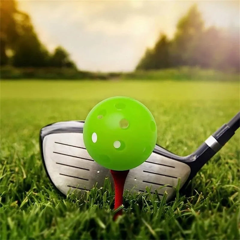 Multi-colour golf practice balls with 26 holes on a green surface.