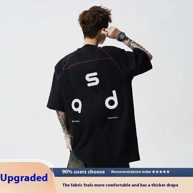 A loose-fit black cotton T-shirt with a white letter print on the front, showing a round neck and short sleeves.