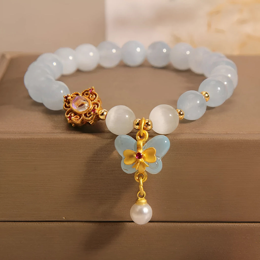Women's adjustable bracelet with an aquamarine crystal butterfly pendant and rhinestone details on a metal chain.