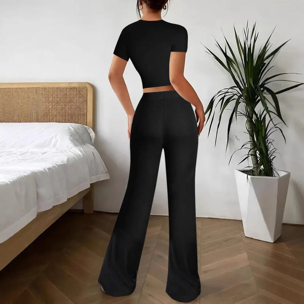 Black women's polyester trousers suit with high-waist trousers and a short-sleeve T-shirt on a hanger.