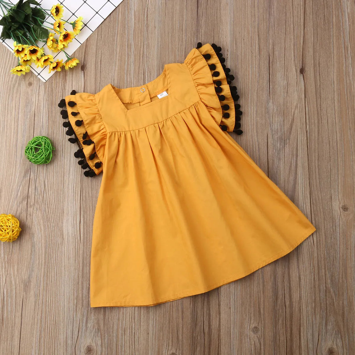 Orange sleeveless dress for toddler girl with shirring detail on front and elasticated back.