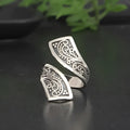 Silver-coloured adjustable minimalist women's ring with a retro design on a plain background.
