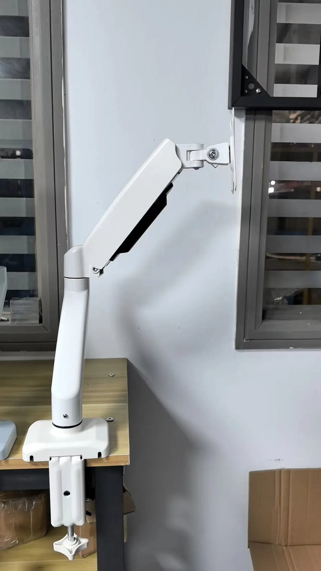 Black LCD screen rotating telescopic bracket elevated on desk with adjustable height and angle