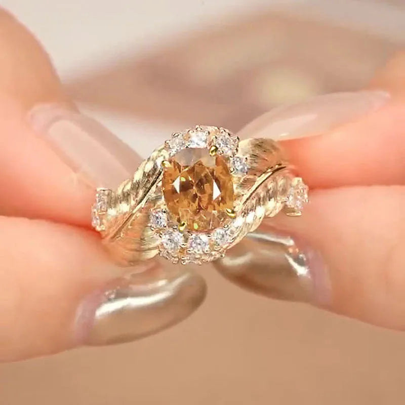 Gold women's ring with embossed feather pattern and yellow zircon stones on geometric copper band