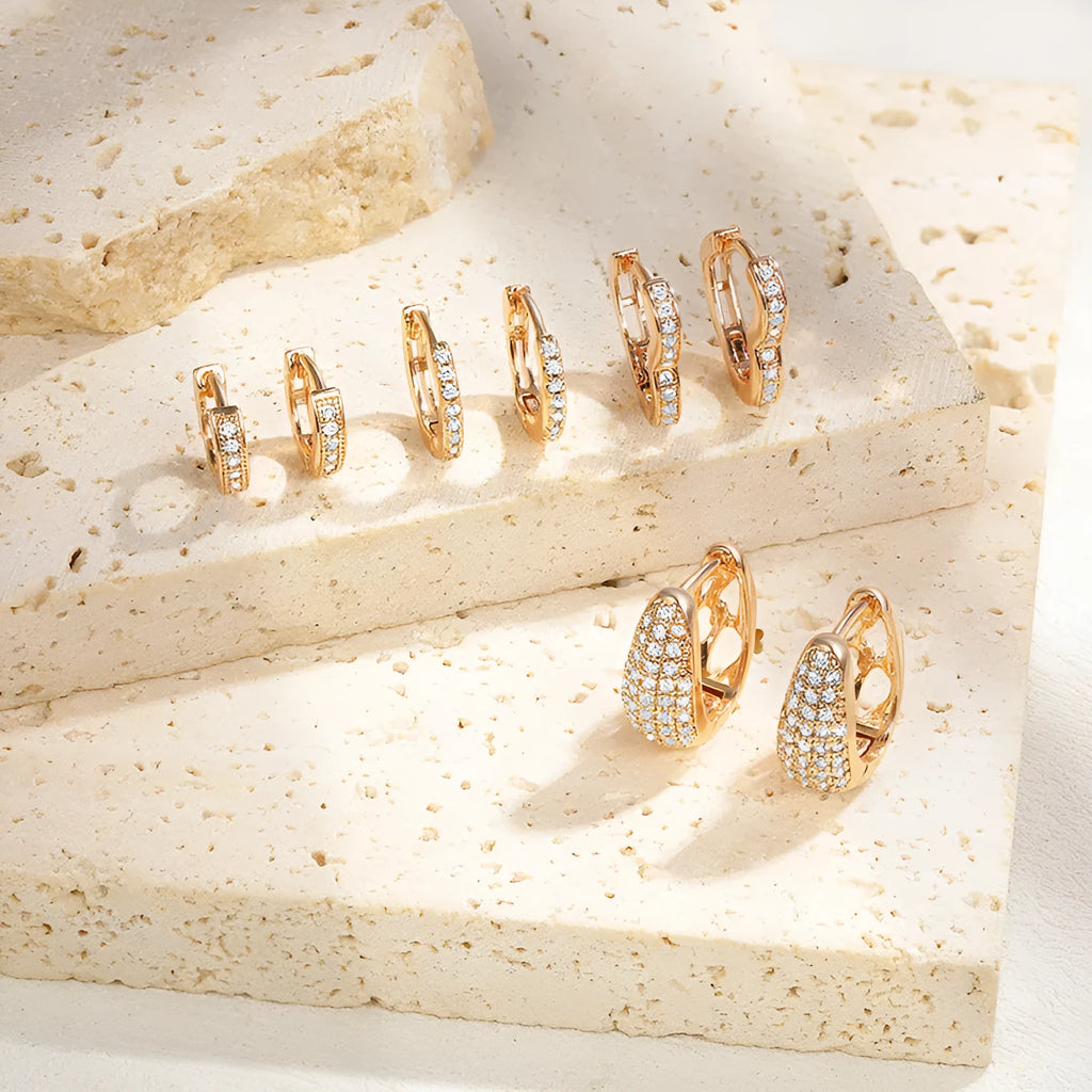 Gold plated heart-shaped ear clip earrings with zircon gang drill details on a white background.