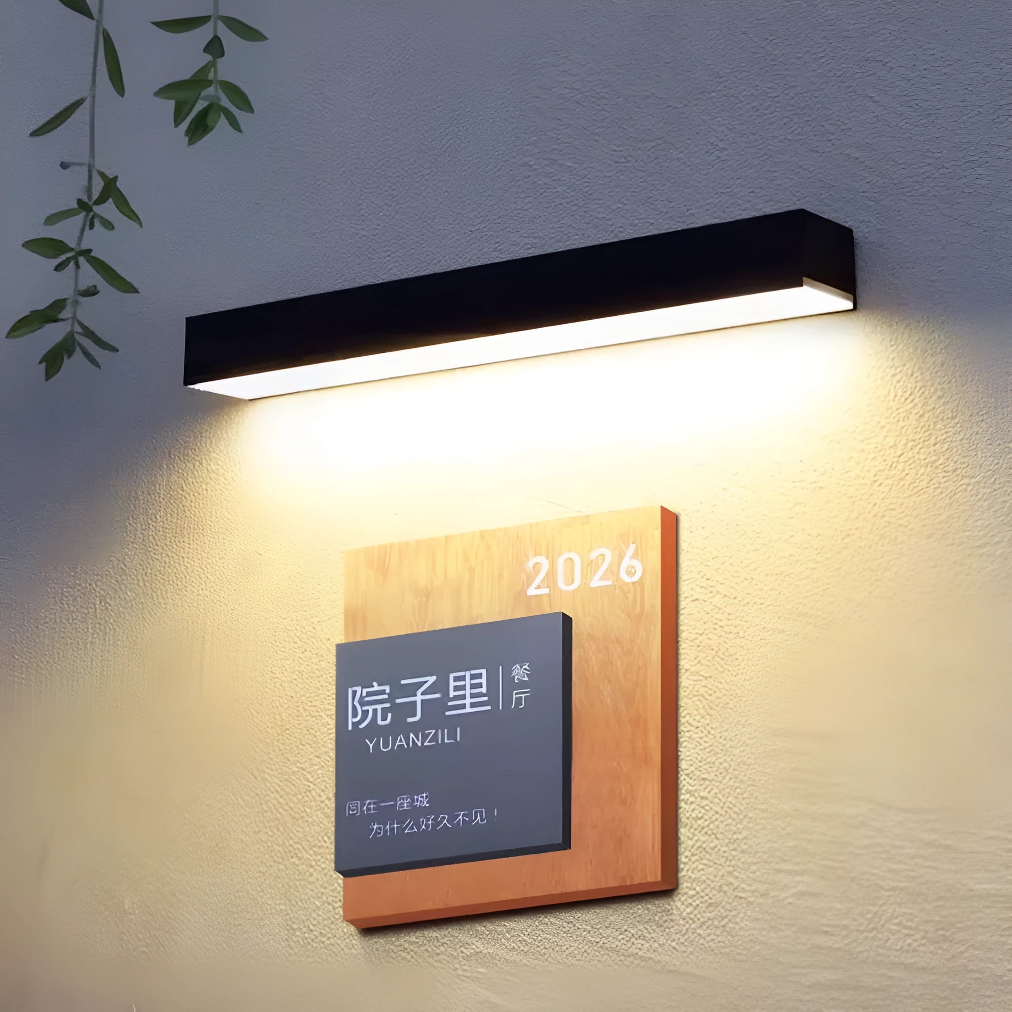 Black solar-powered outdoor wall lamp with integrated solar panel, mounted on a garden wall.