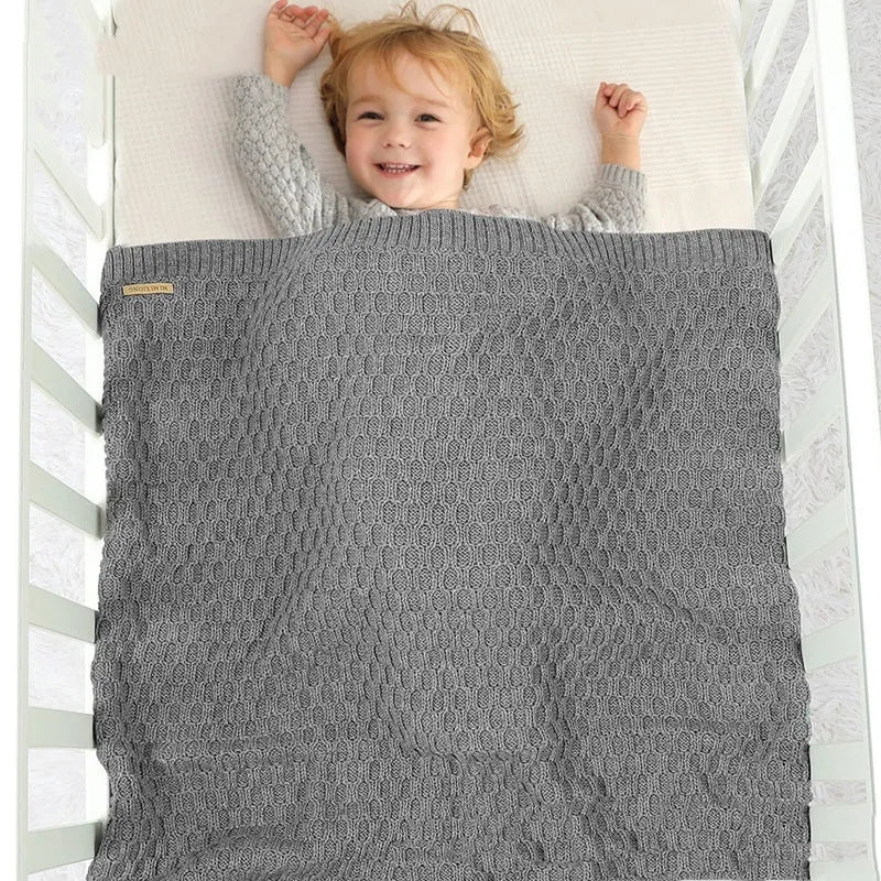 Solid colour infant hug blanket with a three-dimensional lines texture, shown in a soft pink shade.